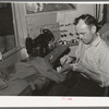 Tailor shortening a pair of trousers. San Augustine, Texas