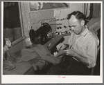 Tailor shortening a pair of trousers. San Augustine, Texas
