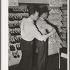 Clerk measuring a customer for a suit of clothes. San Augustine, Texas