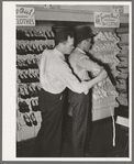 Clerk measuring a customer for a suit of clothes. San Augustine, Texas