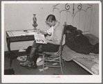Boy reading in bedroom. Note lack of proper bed clothing. Home of A.O. Ryland near Williston, North Dakota