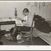 Boy reading in bedroom. Note lack of proper bed clothing. Home of A.O. Ryland near Williston, North Dakota