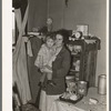 Mother and child in corner of farm home, Sheridan County, Montana