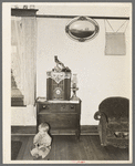 One of the Bakke children in living room of farm house. Note decorations and chair. Near Ambrose, North Dakota
