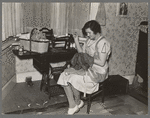 Mrs. Carl Thorson patching clothes in home, Crosby, North Dakota
