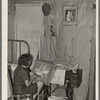 Southeast Missouri Farms. Girl making a hooked rug in bedroom of shack home, La Forge, Missouri