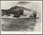 Member of carnival crew resting on hammock. Lasses-White traveling show, Sikeston, Missouri