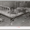 Boy resting on bed in attic of sharecropper shack, New Madrid County, Missouri