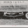 Carnival employee sleeping in hammock underneath wagon, Lasses-White show. Sikeston, Missouri