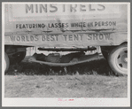 Carnival employee sleeping in hammock underneath wagon, Lasses-White show. Sikeston, Missouri