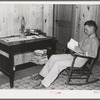 Son of Atkinson family reading at new home, Southeast Missouri Farms