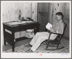 Son of Atkinson family reading at new home, Southeast Missouri Farms