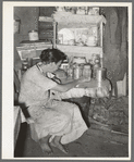 Resident of Tin Town, Caruthersville, Missouri, sitting at kitchen table