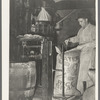 Sewing bag of rice brand after being weighed in rice packaging process, Crowley, Louisiana