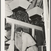 Worker in front hoppers. State rice mill, Crowley, Louisiana