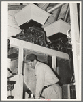 Worker in front hoppers. State rice mill, Crowley, Louisiana