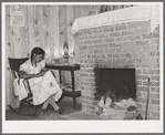 Wife of FSA (Farm Security Administration) client sewing in front of fireplace in her home on Sabine Farms. Marshall, Texas