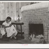 Wife of FSA (Farm Security Administration) client sewing in front of fireplace in her home on Sabine Farms. Marshall, Texas