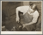 Boot maker putting lower part of boot around the last for fitting. Boot making shop, Alpine, Texas