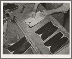 The pattern for the stitching on the uppers is transferred to the leather by means of talc through perforations in the pattern. Boot making shop, Alpine, Texas. Each of the bootmakers has his own patterns which he has fashioned