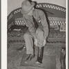 A customer trying on a pair of boots in bootmaking shop. Alpine, Texas