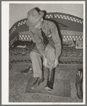 A customer trying on a pair of boots in bootmaking shop. Alpine, Texas