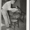 Applying pressure by means of sandbags to glued leather in saddle repairing shop. Alpine, Texas