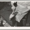Applying glue to cement outer sole to the inner sole of the boot. Cowboy boot shop, Alpine, Texas
