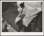 Applying glue to cement outer sole to the inner sole of the boot. Cowboy boot shop, Alpine, Texas