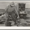 Camp cook at work with chuckwagon in background. Cattle ranch near Marfa, Texas