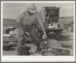 Camp cook at work with chuckwagon in background. Cattle ranch near Marfa, Texas