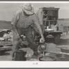 Camp cook at work with chuckwagon in background. Cattle ranch near Marfa, Texas