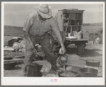 Camp cook at work with chuckwagon in background. Cattle ranch near Marfa, Texas