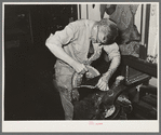 Applying cement for gluing leather of saddle to the base before sewing. Saddle shop, Alpine, Texas