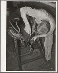 Rivet work in saddle repair shop. Alpine, Texas