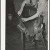 Workman repairing saddle. Alpine, Texas, saddle shop