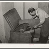 Selecting a piece of leather from the tempering chest. Cowboy boot shop, Alpine, Texas