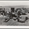 Camp cook at work with chuck wagon in center and truck for carrying bed rolls at left. Cattle ranch near Marfa, Texas