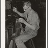 Sewing pieces of leather together on saddle maker's bench. Saddle shop, Alpine, Texas