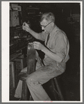 Sewing pieces of leather together on saddle maker's bench. Saddle shop, Alpine, Texas