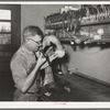 Repairing a saddle. Saddle shop, Alpine, Texas