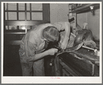 Saddle maker sewing saddle while repairing it. Saddle shop, Alpine, Texas