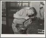 Repairing saddle. Saddle shop, Alpine, Texas
