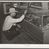 Cowboy looking at display of spurs. Ranch supply store, Alpine, Texas