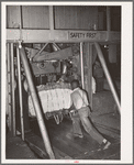 Placing bale of cotton into compressing unit. Compress, Houston, Texas. After going through the compress the bale of cotton is about one third its original size