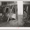 Placing a bale of cotton into compressing unit. Compress, Houston, Texas. After going through compresser bale of cotton is about one third its original size. Houston, Texas