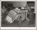 Action in loading a bale of cotton onto truck for transporting to compress. Houston, Texas