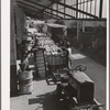 Unloading bales of cotton from truck-drawn trailers at compress, Houston Texas. Cotton was transported to the compress from Oklahoma in large trucks in background