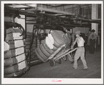 Removing bale of cotton from conveyer. Compress, Houston, Texas