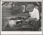 Man slicing barbecue at lunch stand at the Gonzales County Fair. Gonzales, Texas